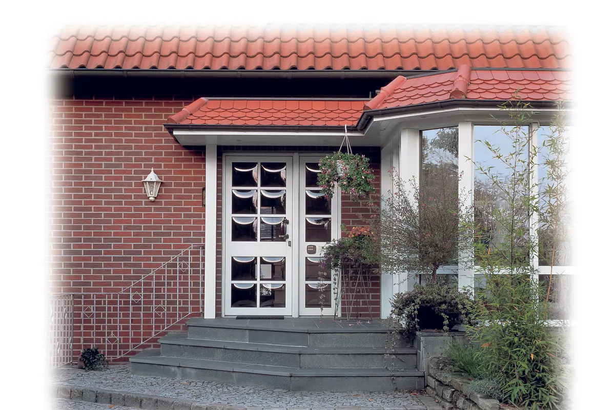 Brick house entrance with glazed doors at the top of a few steps