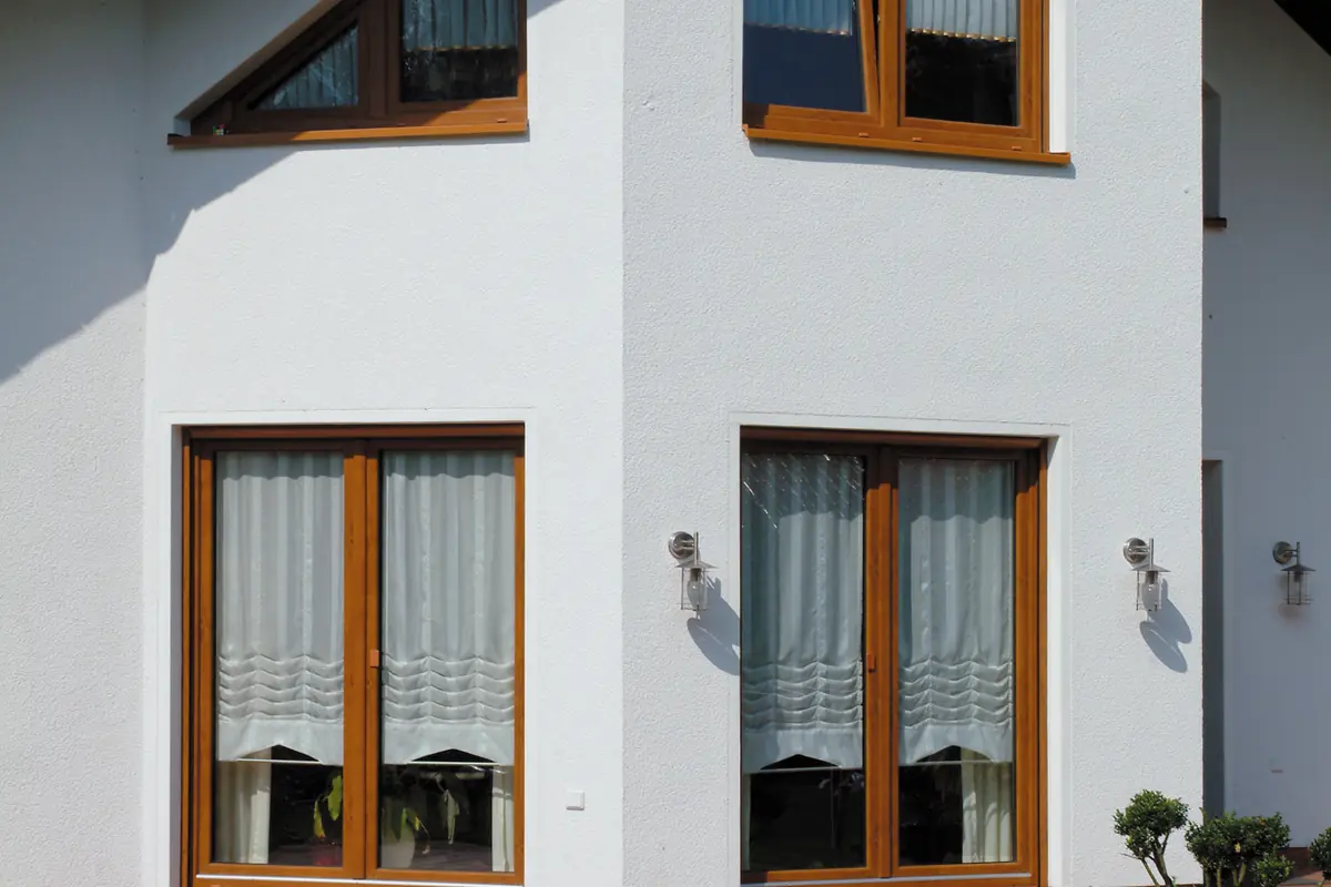 White house with wooden-effect windows and a triangular gable window