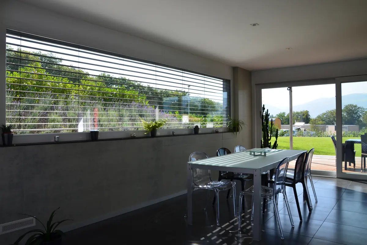 Dining area with a wide sliding window onto a garden