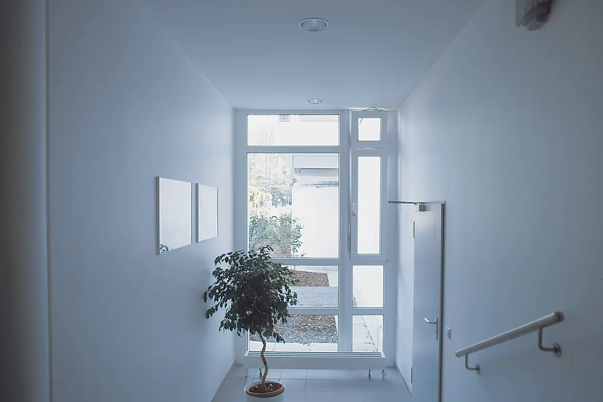 Tall white window at the end of a bright hallway