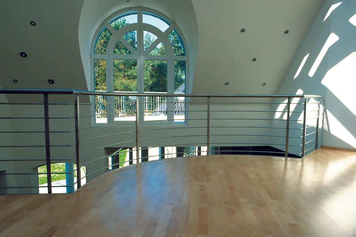 Bright room with an arched window and a gallery rail