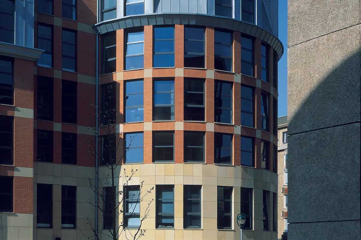 Edificio en esquina con todos los huecos volcados a la misma calle. Con locales a pie de calle, el sonido asciende pegado a la fachada y llega arriba con menos pérdida de la que la gente supone.