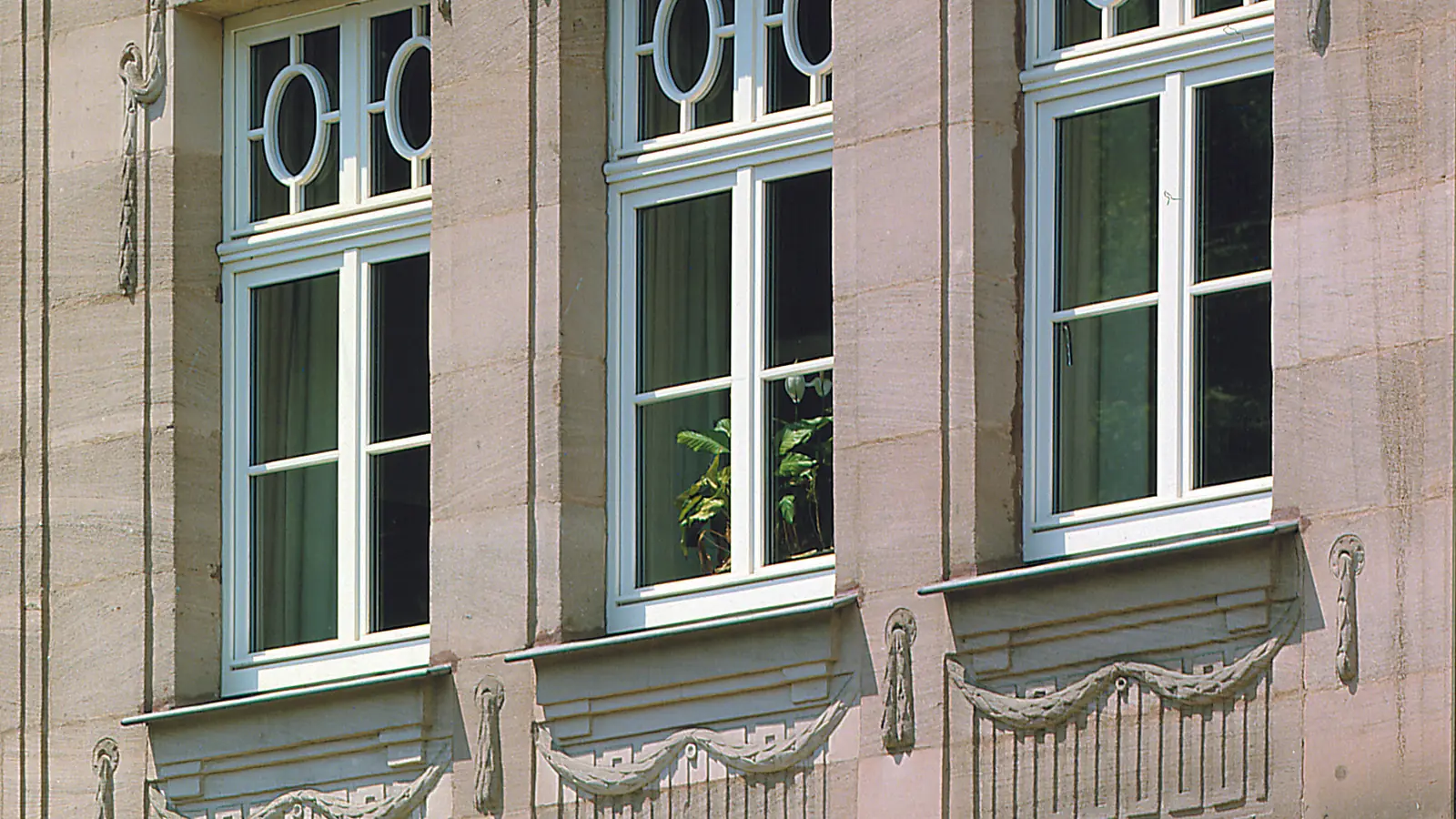 Fachada con ventanas grandes y pequeñas mezcladas, unas casi todo cristal y otras casi todo marco