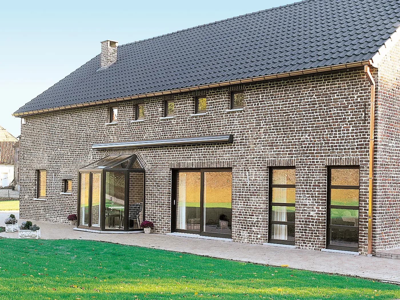 Facade renovation: dark-finish frames on a brick facade